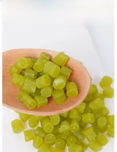 Detailed view of light green miniature resin cylinder beads in a wooden spoon