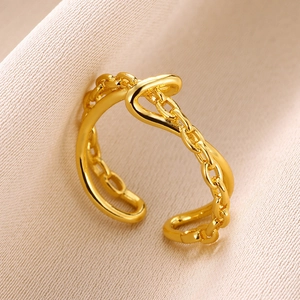 Macro shot of gold chain knot ring with adjustable open band on pink silk fabric