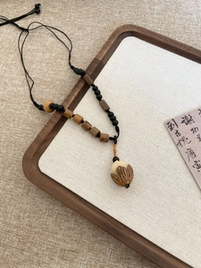 Detailed shot of Chinese style wooden bead necklace with a lotus bud carved pendant