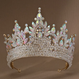Close-up of golden Baroque crown with pink iridescent crystals and sparkling rhinestones