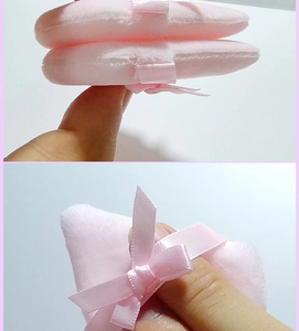Close-up of pink velvet powder puffs featuring soft plush texture and ribbon bow detail