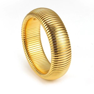 Detailed close-up of golden Tubogas style titanium steel bracelet with spiral texture