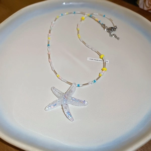 Detail of colorful beads and iridescent starfish pendant on a beach-style necklace