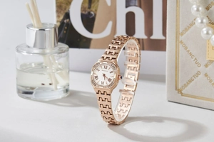 Detailed macro of rose gold square watch dial with roman numerals and crystals