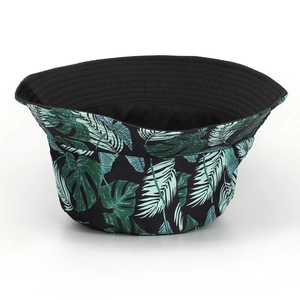 Détail d'un chapeau bob réversible avec imprimé feuilles tropicales et doublure noire