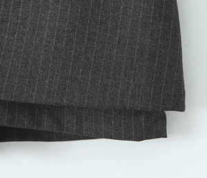 Detailed view of dark grey pinstripe fabric texture for professional trousers or skirts