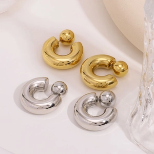 Minimalist C-shaped hollow earrings in gold and silver finish on white textured cloth