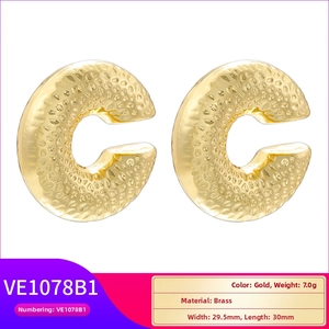 Detailed view of hammered gold brass C-shaped earrings with unique texture and 30mm size