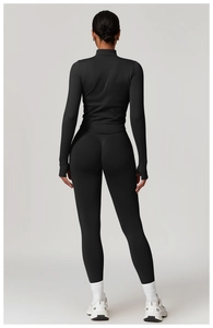 Vue arrière d'un ensemble de sport noir sans couture avec leggings et manches passe-pouce