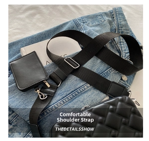 Detail of black quilted crossbody bag with a wide fabric strap and a small coin purse