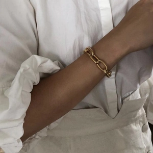 Macro detail of chunky gold chain bracelet worn on wrist with 18k vacuum plating