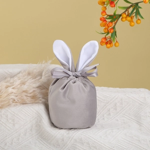 Detail of grey velvet Easter bunny ear gift bag with a silk ribbon bow on white fabric