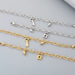 Close-up of magnetic heart lock and key charms on gold and silver chain bracelets
