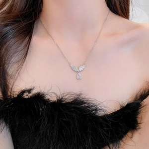 Detail of silver angel wing necklace with pink teardrop crystal on female model