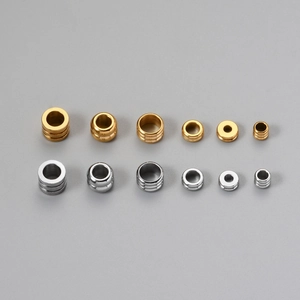 Vista dettagliata di distanziatori cilindrici in oro e argento per gioielli DIY