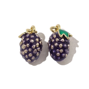 Macro detail of two purple grape charms with golden metal base and green enamel leaves