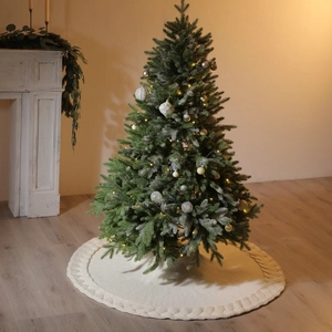 Knitted 48-inch off-white Christmas tree skirt with woven texture under a decorated tree