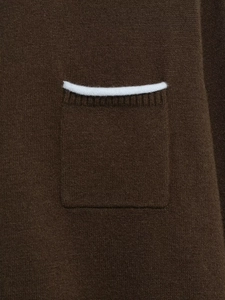 Detail of a dark brown knit cardigan featuring a contrast white trim on a rectangular pocket