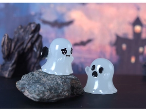 Close-up of two luminous owl ghost figurines for Halloween micro landscape decoration