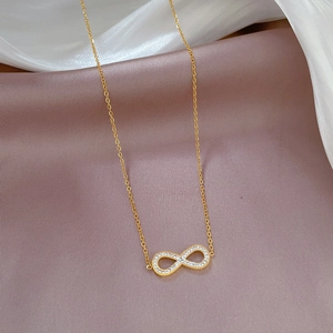 Detail of gold infinity pendant with rhinestones on silk fabric necklace display