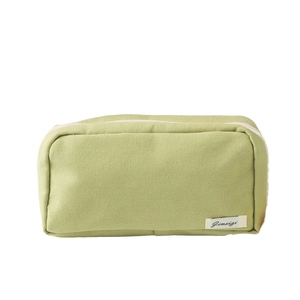 Green canvas pencil case with large capacity and white woven label on white background