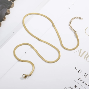 Minimalist gold snake chain set with adjustable lobster clasp on a fashion magazine