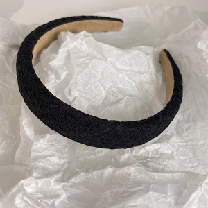 Detail of elegant black lace headband with non-slip khaki velvet inner lining