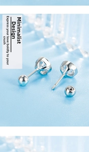 Macro shot of silver screw-back earrings with zircon stone and heart-shaped hollow base