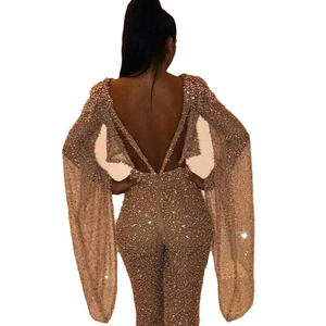 Detailed back view of a sequined backless jumpsuit featuring long flared sleeves in gold