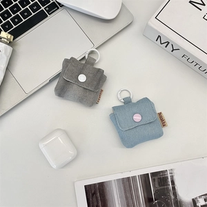 Mini denim earphone case with hook in blue and grey colors on a modern desk setup
