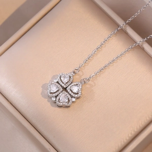 Gros plan du collier trèfle à quatre cœurs en argent avec zircons dans son écrin à bijoux