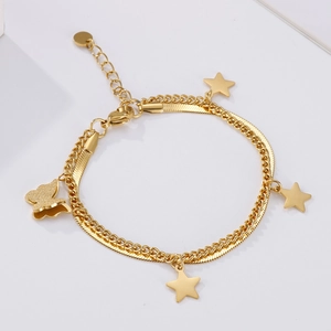 Detail of gold double-layer bracelet with star and butterfly charms on white background