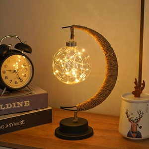 Detail of moon-shaped LED lamp with warm copper lights and woven jute rope texture