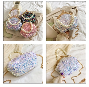 Detail of iridescent sequin shell bag with pearl handle and golden kiss lock frame