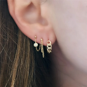 Close-up of S925 sterling silver gold chain earrings and studs worn on a model ear
