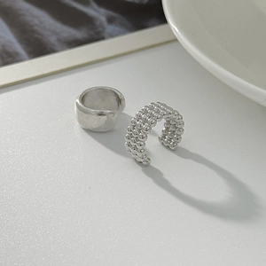 Detail view of silver ear cuff set featuring smooth and triple-beaded texture styles