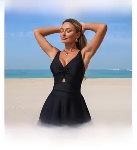 Detail of black V-neck swimsuit with laser-cut hollow lace hem against a beach background