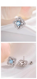 Macro detail of snowflake zircon earrings with light blue center stone and silver petals