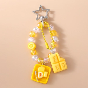 Detail of yellow beaded keychain with star clasp, lemon slice and milk chocolate charm