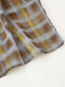 Detailed view of chiffon plaid fabric with rolled edges and sheer dye pattern