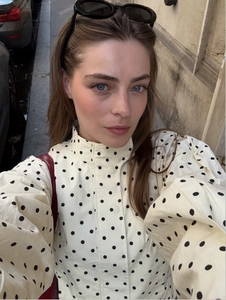 Detailed view of polka dot print jacket with high collar and elegant puff sleeves