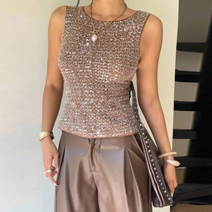 Détail des paillettes dorées scintillantes sur un débardeur ajusté pour femme