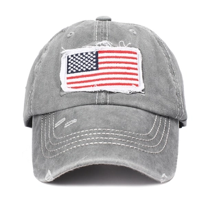 Close-up of vintage washed cotton baseball cap with American flag embroidery and distressed holes