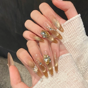 Faux ongles faits main œil de chat ambre avec dégradé doré, cristaux et motifs étoiles