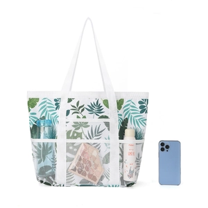 Große Strandtasche aus Netzgewebe mit Tropenblatt-Muster und praktischen Außentaschen.