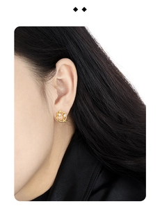 Close-up of gold branch wreath earrings with white crystals on a female model