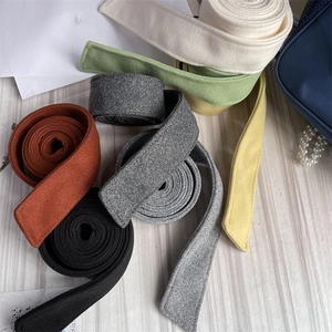 Detailed view of multi-color wool coat belts showing stitched edges and felt texture