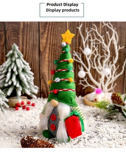 Détail d'un gnome de Noël avec chapeau sapin vert et cadeau rouge sur fond de neige