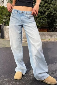 Photo en extérieur d'un jean bleu clair à taille haute et jambe large au délavage vintage