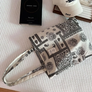 Detail of paisley pattern cotton canvas tote bag with woven label on quilted surface